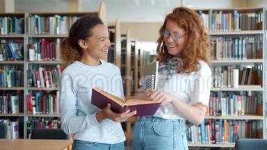 快乐的女生在图书馆聊天，讨论书中的笑